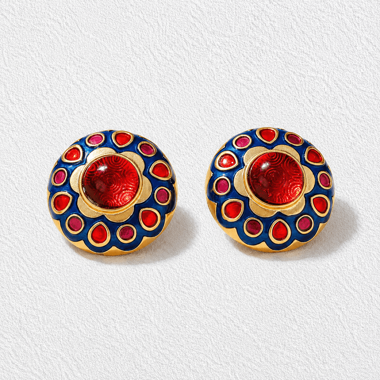 LÁGRIMAS DE TIMANFAYA • Pendientes botón bañados en oro con esmalte azul y cabuchones en tonos rojo y granate •